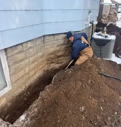 A professional waterproofs the exterior of a house in Fitchburg, WI